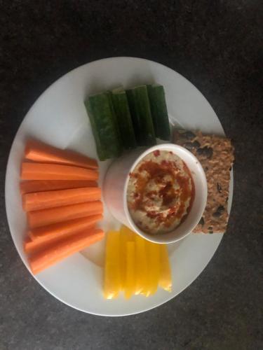 a plate of food with vegetables and a bowl of dip at Foresters Lodge bed and breakfast, near loch ness in Inverfarigaig