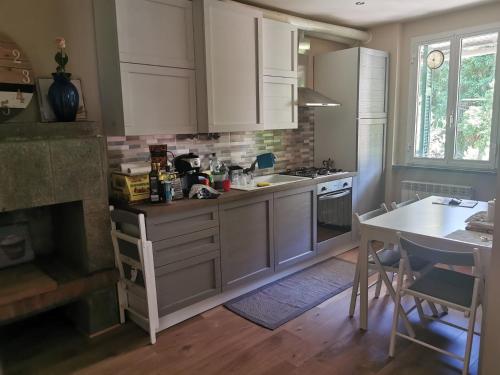 a kitchen with white cabinets and a table and a stove at Itaca in Varazze