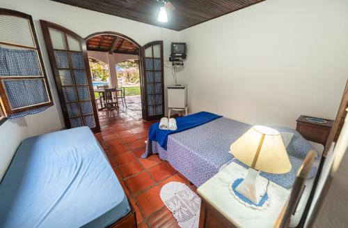 una camera da letto con un letto e un tavolo con una lampada di Pousada da Gibinha a Campina do Monte Alegre