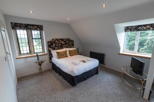 a small bedroom with a bed and a television at Sneaton Castle in Whitby
