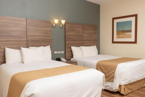 a hotel room with two beds with white sheets at Best Western Cumbres Inn Cd. Cuauhtemoc in Cuauhtémoc
