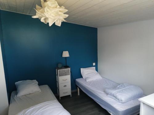 a bedroom with two beds and a blue wall at Charmante maison à 500 m de la côte, pour 4 in Notre-Dame-de-Monts