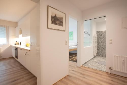 a kitchen with white cabinets and a door leading to a bedroom at City Flair in Seenähe in Bregenz