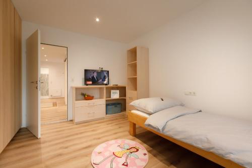 a bedroom with two beds and a tv in it at City Flair in Seenähe in Bregenz