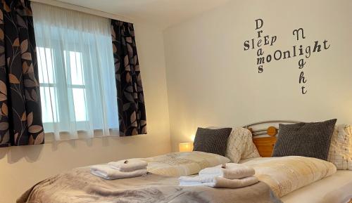 1 dormitorio con 1 cama con toallas en Apartment Krämerhaus Annaberg, Dachstein West en Annaberg im Lammertal