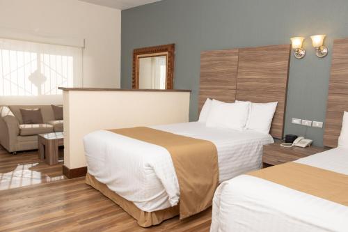 a hotel room with two beds and a couch at Best Western Cumbres Inn Cd. Cuauhtemoc in Cuauhtémoc