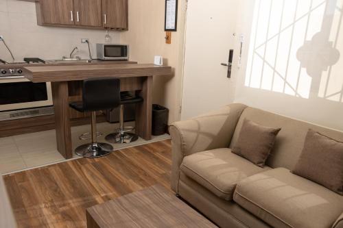 a living room with a couch and a table and a kitchen at Best Western Cumbres Inn Cd. Cuauhtemoc in Cuauhtémoc