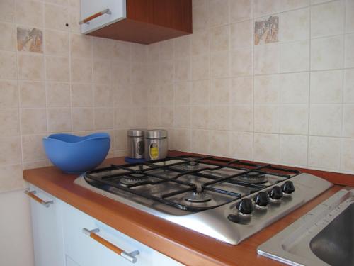 a kitchen stove top with a blue bowl on the counter at Holiday in SARDINIA in Pula, at the sea of ​​Nora in Pula