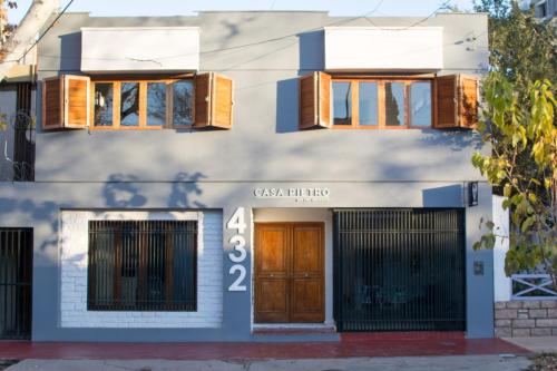 een wit gebouw met een bruine deur en ramen bij CASA PIETRO in Mendoza