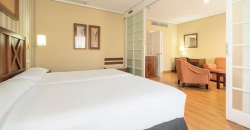 a bedroom with a large white bed in a room at Ilunion Alcora Sevilla in San Juan de Aznalfarache