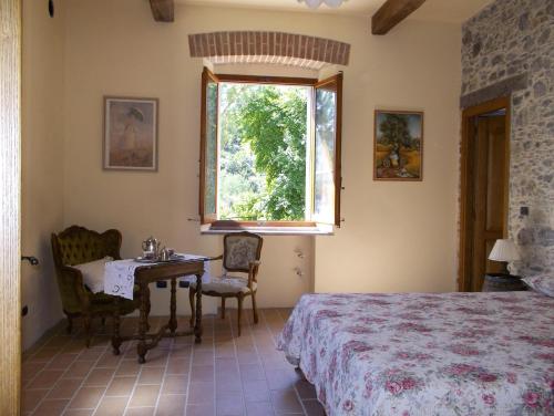 een slaapkamer met een bed, een tafel en een raam bij Agriturismo A Trasea in Varese Ligure