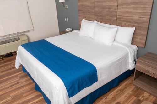 a hotel room with a large bed and a table at Best Western Plus Chihuahua Aeropuerto in Chihuahua