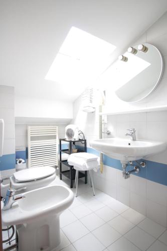 ein weißes Badezimmer mit 2 Waschbecken und einem Spiegel in der Unterkunft Hotel Croce Di Malta in Novara