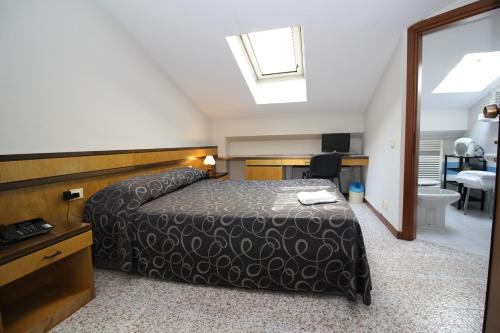 a bedroom with a bed and a bathroom at Hotel Croce Di Malta in Novara