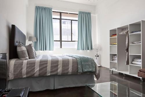 1 dormitorio con cama y ventana grande en Maboneng Studio Loft, en Johannesburgo