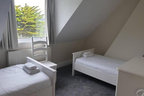 a small room with two beds and a window at Beautiful house next to Beach & Park nr Zoo Newly refurbished in Kent