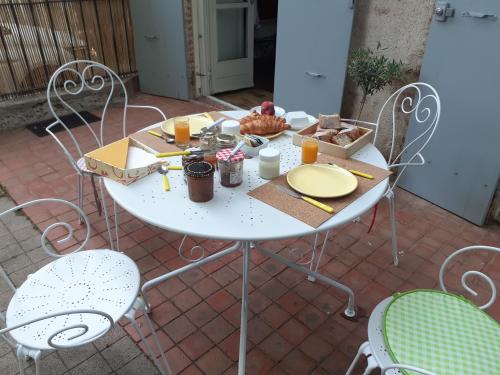 - une table blanche avec de la nourriture sur la terrasse dans l'établissement SENTIMIR, à Saint-Génis
