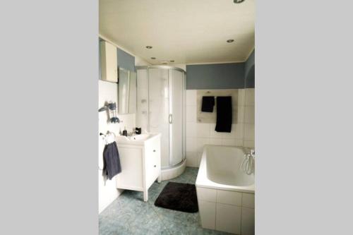 a bathroom with a tub and a toilet and a sink at Gutshof Dobschütz - Urlaub auf dem Bauernhof in Nossen