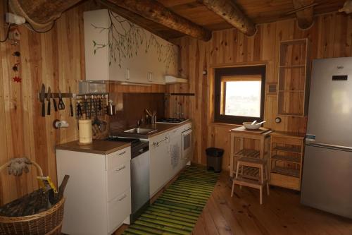 a kitchen with white appliances and wooden walls and wooden floors at Casa Jaumet: un lloc de pau on escoltar el silenci in Aramunt