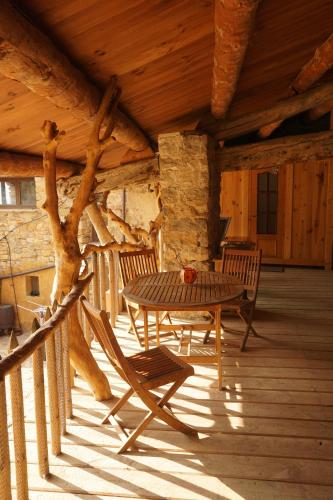 a wooden patio with a table and chairs on a porch at Casa Jaumet: un lloc de pau on escoltar el silenci in Aramunt