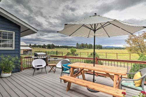 a wooden deck with a picnic table and an umbrella at Montana Cottage Easy Drive to Glacier Natl Park! in Columbia Falls