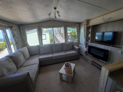 a living room with a couch and a flat screen tv at Hendre Coed Isaf Caravan Park in Barmouth
