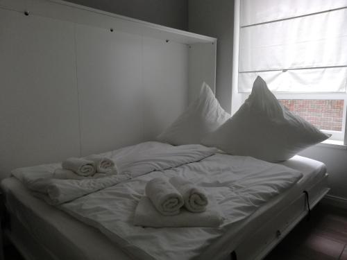 a white bed with towels on it with a window at Ferienwohnung am Welper-Wald-Vechta-Süd in Vechta