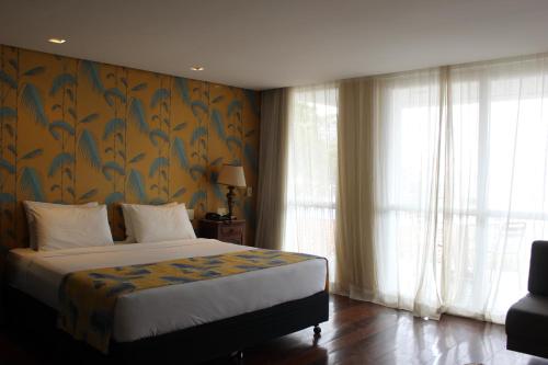 a bedroom with a bed with a floral wallpaper at RARO Ipanema Boutique Hotel in Rio de Janeiro
