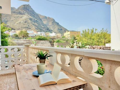 - une table avec des livres et une tasse de café sur le balcon dans l'établissement Casa Ana con balcón, à Punta del Hidalgo