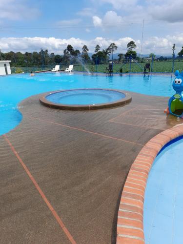 a large swimming pool with a blue pool at Apartamentos a 3 minutos del Parque del Café in Armenia