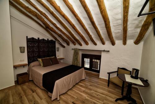 1 dormitorio con 1 cama y 1 mesa en una habitación en Casa Las Tinajas en Iznájar