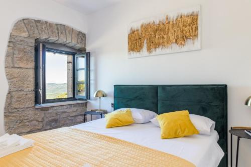 sypialnia z dużym łóżkiem z żółtymi poduszkami w obiekcie Villa Grazia - with heated salt water Pool w mieście Pazin
