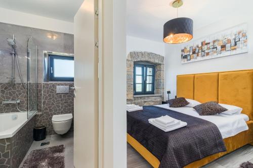 sypialnia z łóżkiem, wanną i umywalką w obiekcie Villa Grazia - with heated salt water Pool w mieście Pazin