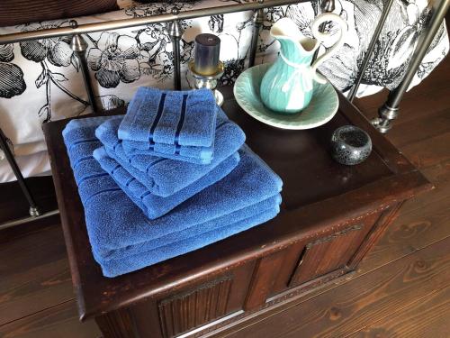 - une table avec des serviettes bleues et un vase dans l'établissement NO5 Chambre D'hotes, à Courcôme