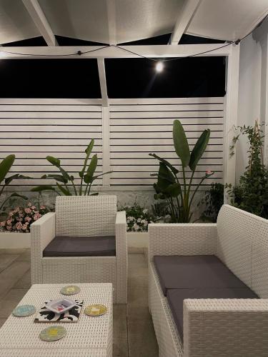a patio with two chairs and a table and sidx sidx sidx at i Giardini di Rita- Rooms & Garden Loft in Margherita di Savoia