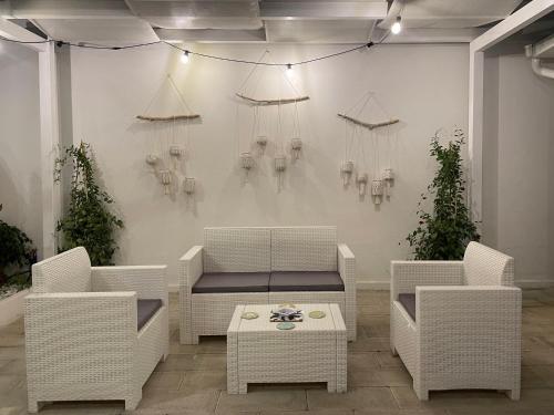 a room with white wicker chairs and a table at i Giardini di Rita- Rooms & Garden Loft in Margherita di Savoia