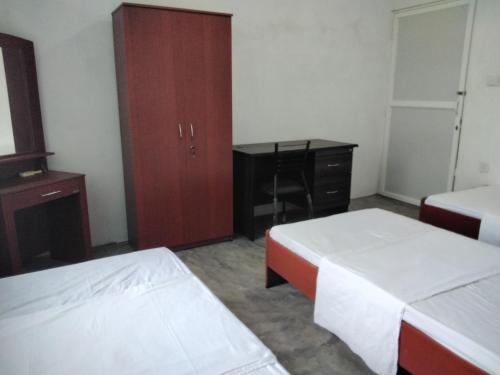 a bedroom with two beds and a desk and a cabinet at The Esence of Sri Lanka in Ahungalla