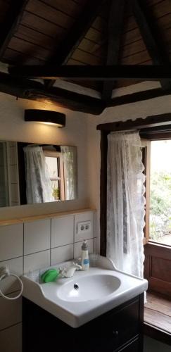 a bathroom with a white sink and a window at La Casita de la Vega in Icod de los Vinos