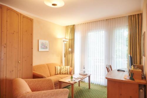 a living room with a couch and a table at Flairhotel Hubertus in Bad Zwischenahn