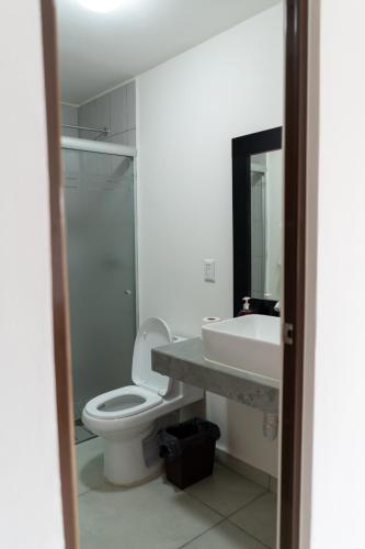 a bathroom with a white toilet and a sink at Departamento La Choza Central Pool in GDL downtown in Guadalajara