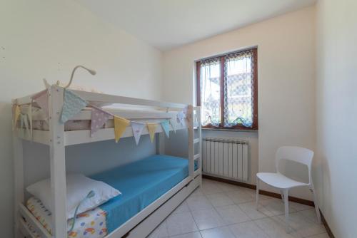 a bedroom with two bunk beds and a chair at La Feriolina - Appartamento al lago con giardino privato in Baveno