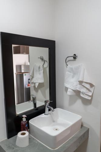 a bathroom with a white sink and a mirror at Departamento La Choza Central Pool in GDL downtown in Guadalajara
