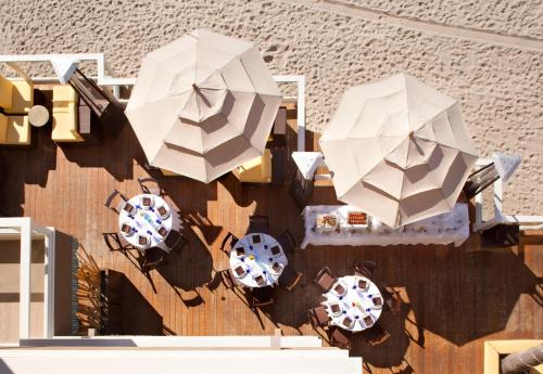 two white umbrellas on the side of a building at Pacific Edge Hotel on Laguna Beach in Laguna Beach