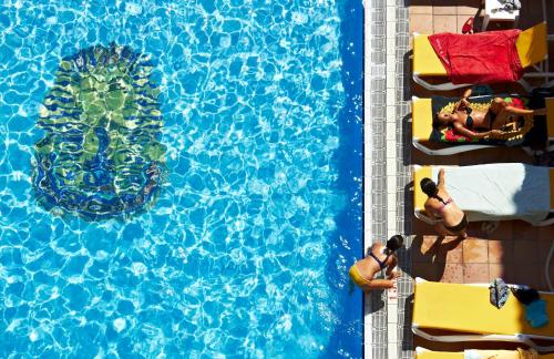an overhead view of a swimming pool with people in the water at BLUESEA Copacabana in Lloret de Mar