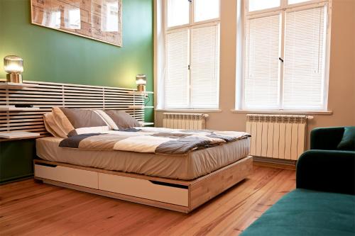 a bedroom with a large bed in a room with windows at Apartament Riesling in Zielona Góra
