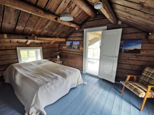 - une chambre avec un lit, une porte et une chaise dans l'établissement Holiday Home Justadvika, à Justad