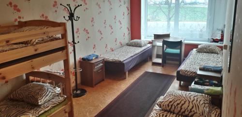 Zimmer mit 3 Etagenbetten und einem Tisch in der Unterkunft Obinitsa Puhkemaja in Obinitsa