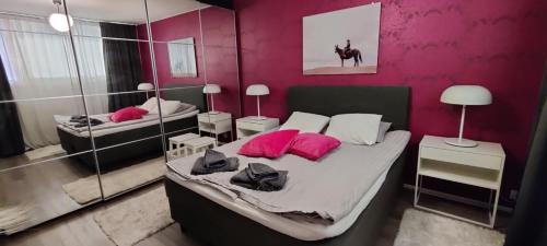 a bedroom with two beds with pink pillows and a mirror at Freshly renovated apartment, perfect for couple in Kerava