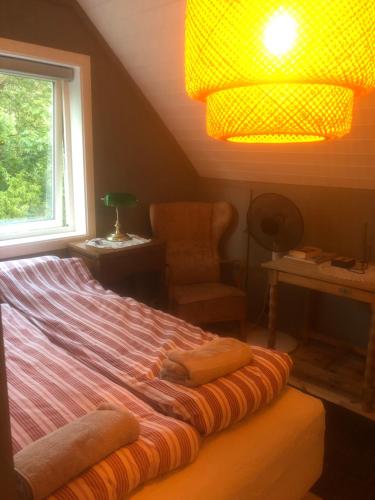 Schlafzimmer mit einem Bett, einem Fenster und einem Stuhl in der Unterkunft Aid og Svein’ s sentrumsnære panorama hjem in Kristiansand