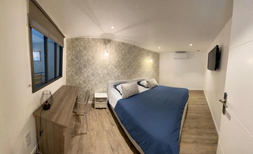 a small bedroom with a blue bed and a window at Le séquoia in Saint-Sébastien-sur-Loire